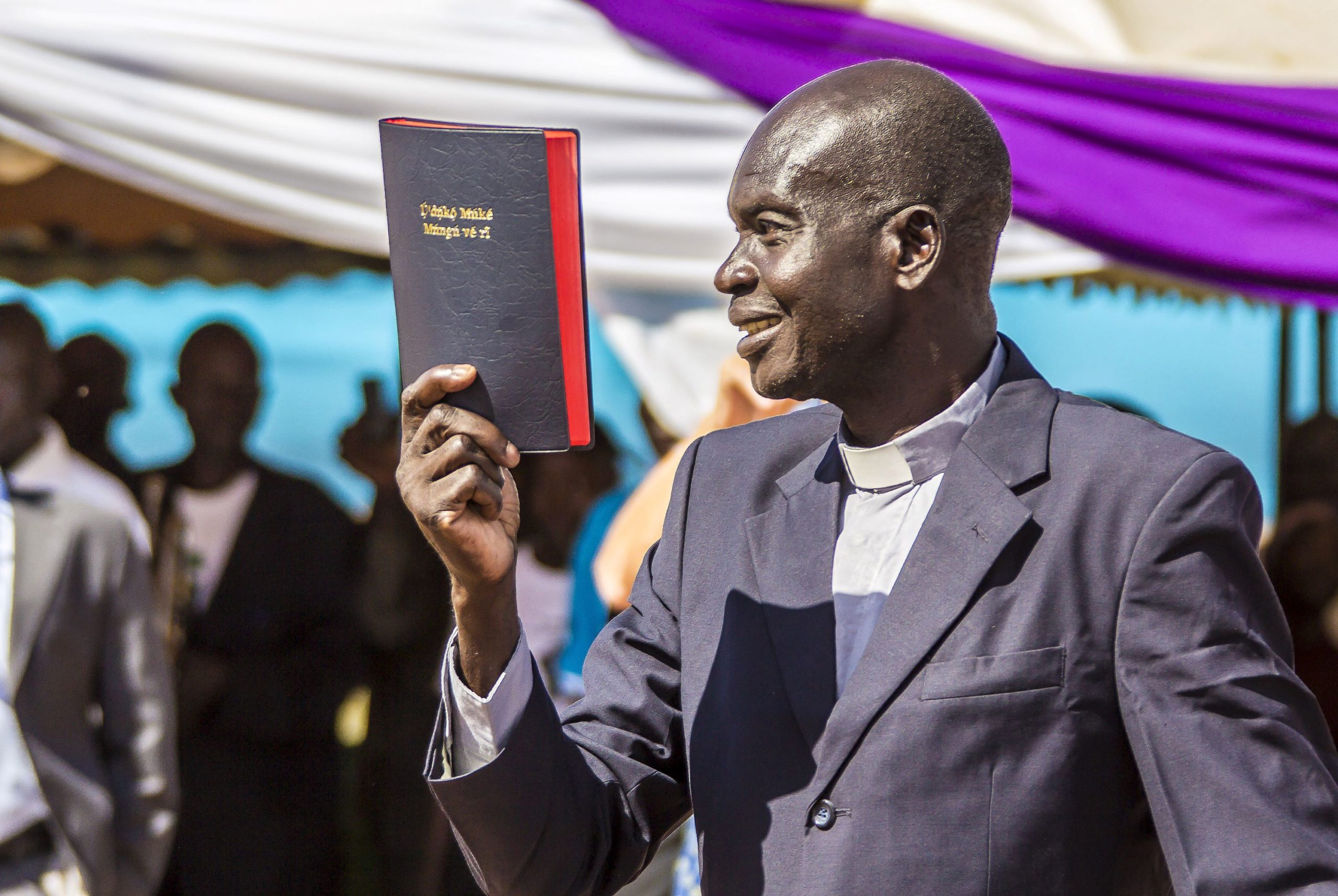 Rev Isaac Kenyi, the Keliko team leader from South Sudan, holds up the New Testament at the launch on 11 August 2018