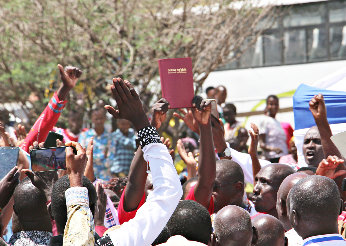 Image of the Ilchamus New Testament being held up at the launch event