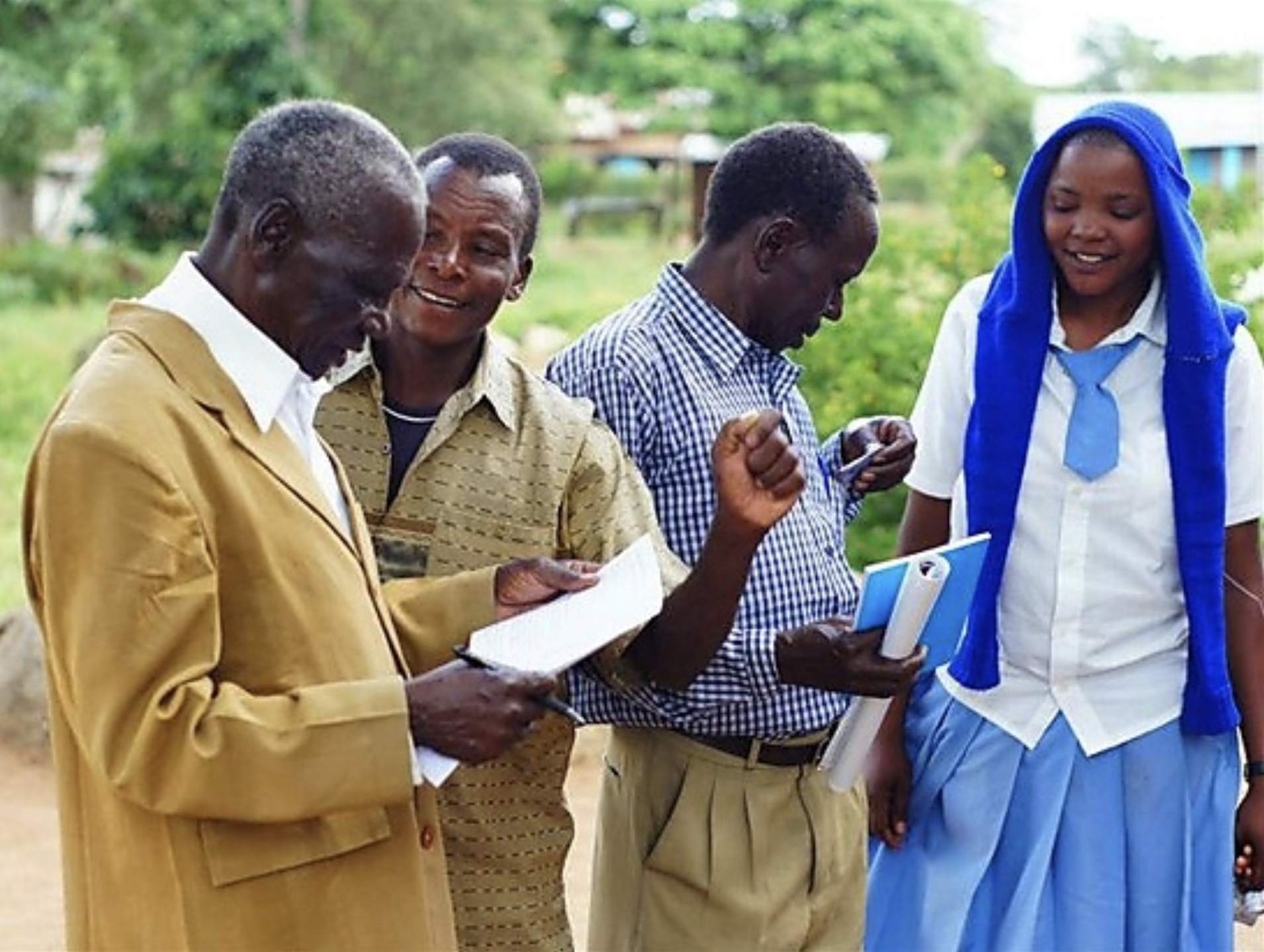 Image of Ikoma speakers enjoying the book of Luke in their language