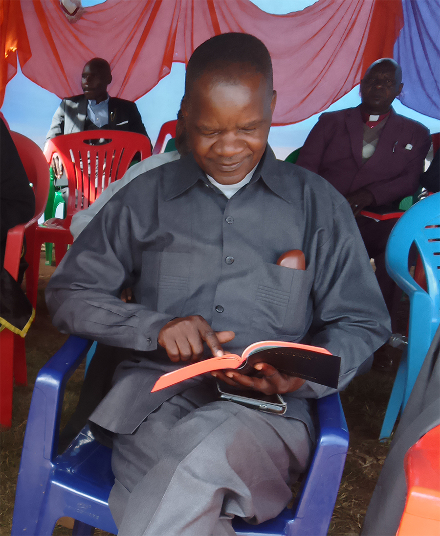 Image of a man enjoying reading his Nyiha New Testament