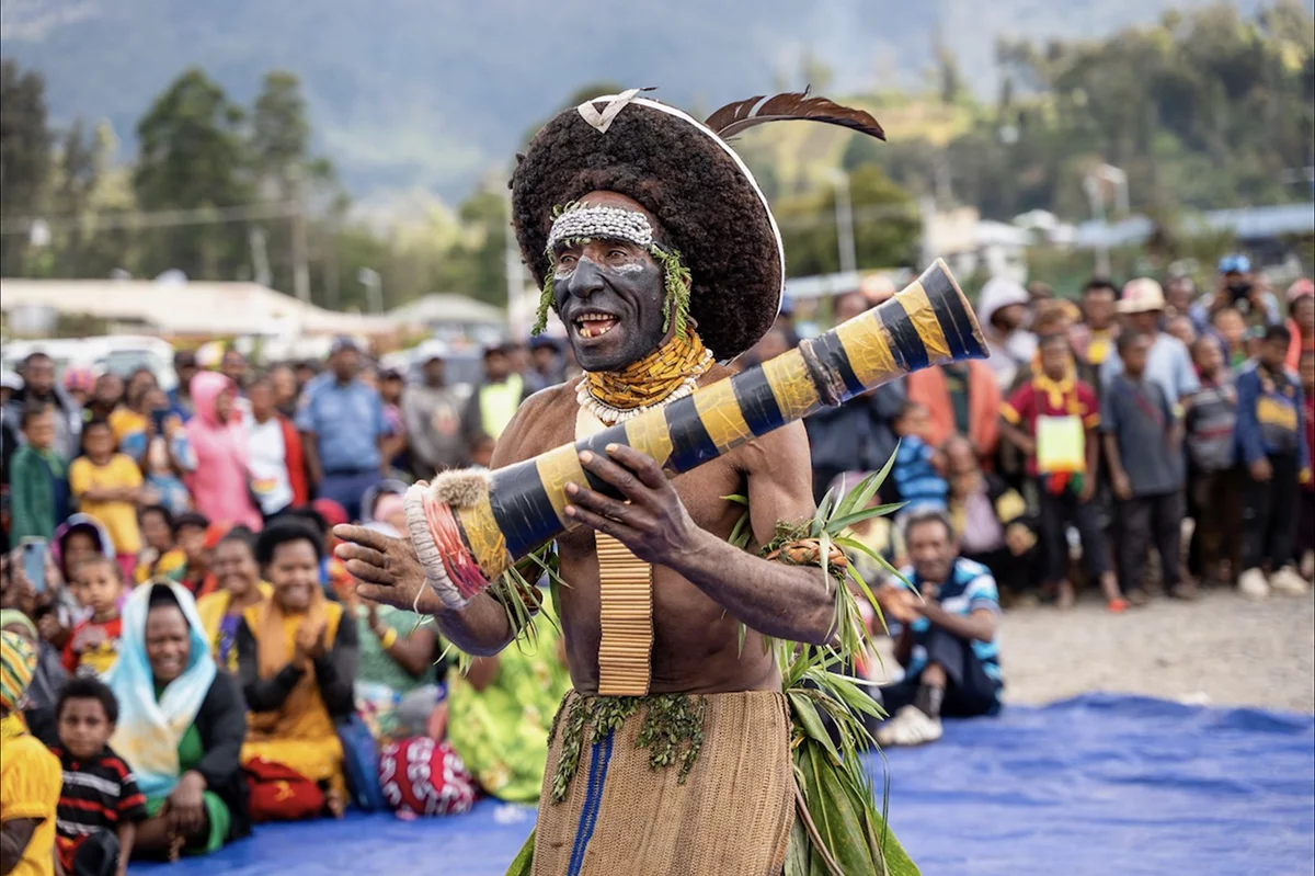 Image of an Engan man playing a drum at the Enga New Testament launch